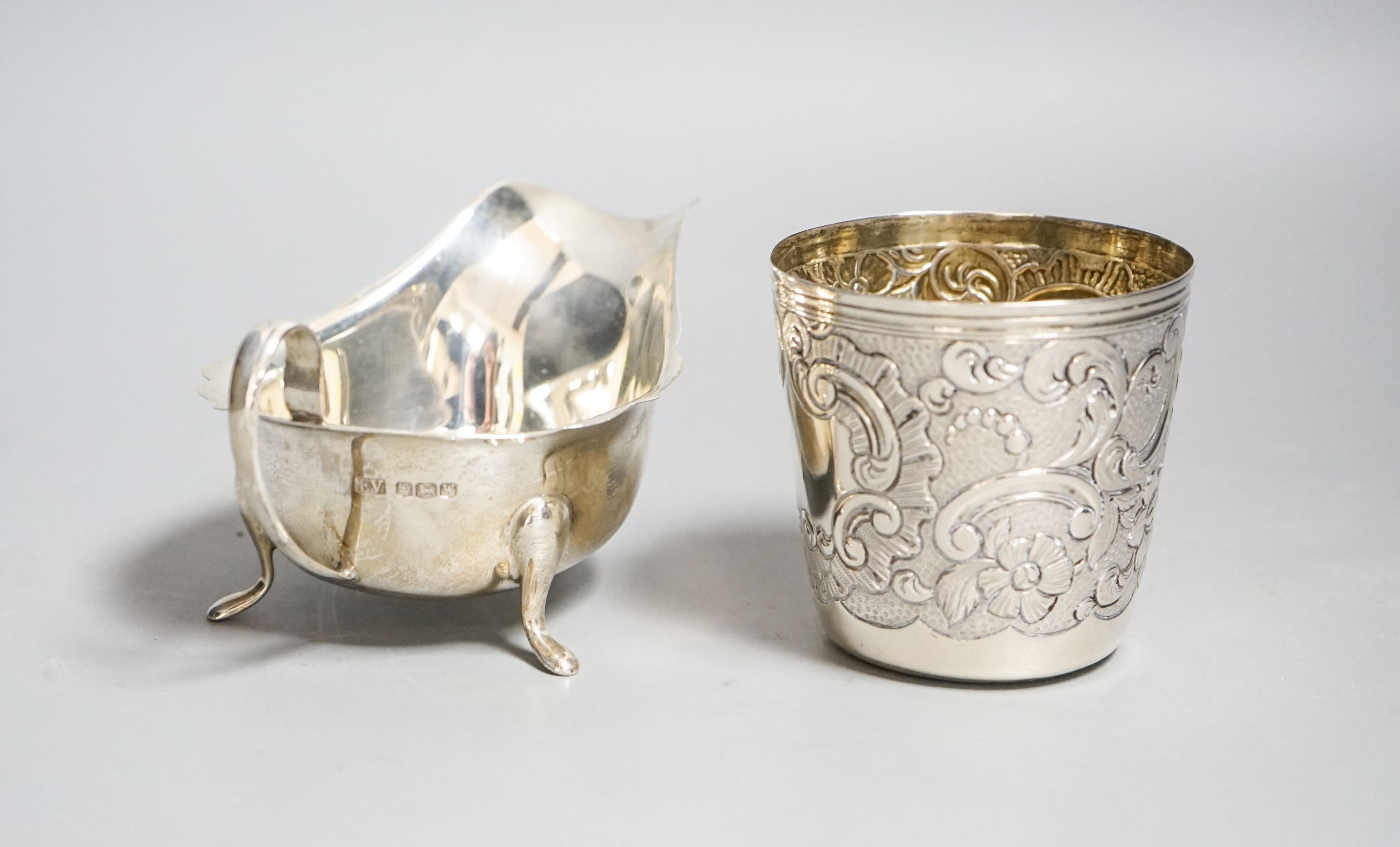 A 19th century Portuguese white metal tumbler, 7cm and a later silver sauceboat, 6.5oz.